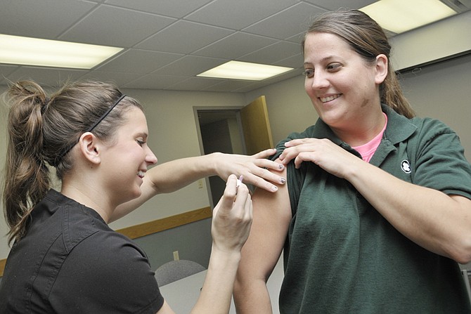 
University of Missouri nursing student Lauren Swankoski administers this year's flu shot Friday to Capital Region Medical Center employee Megan Jones, a unit clerk in ICU. Hospital employees were offered the preventive shot.