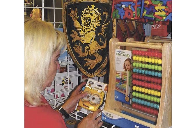 Toys R Us assistant manager Brenda Sanders straightens shelves in the newly opened store at the Capital Mall in Jefferson City. The store is one of many that will open for the holiday season. 