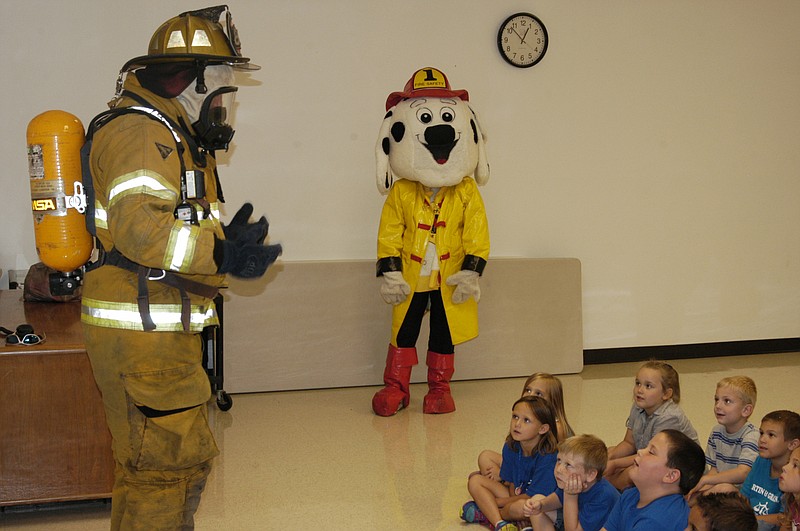 Democrat photo / David A. Wilson
Mark Cram, left, dons the full firefighting outfit for a group of California Elementary kindergartners, as the Fire Pup watches from the back of the room. 
