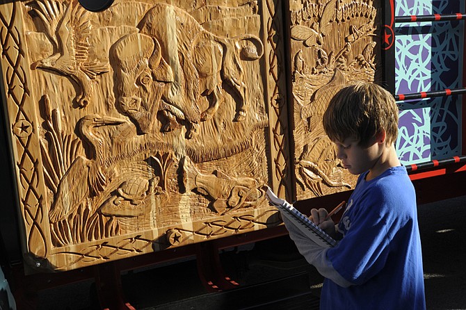 Matthew Kirchner, above, chose to sketch the turtle carved into the wooden driver's side door of the Pakistani Cargo Truck Initiative at the Cole County R-1 Schools Monday. 