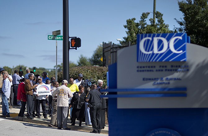 Protestors demonstrate against the government shutdown outside the Centers for Disease Control and Prevention, Tuesday, Oct. 8, 2013, in Atlanta. About two dozen people protested outside the CDC on Tuesday afternoon, trying to cast a harsh spotlight on the temporary federal shutdown. The small group called on Congress to vote on a measure that would restart federal funding.