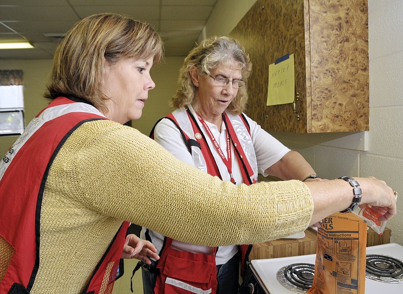 The Heart of Missouri Chapter of the American Red Cross staged a mock disaster drill Tuesday at the First Baptist Church Activity Building. Here, Nancy Sell, near, and Margaret Kennedy prepare one of the Heater Meals provided by the Red Cross. Sell is the Major Gift Officer for the Heart of Missouri Chapter of the Red Cross, and Kennedy volunteers with the agency.