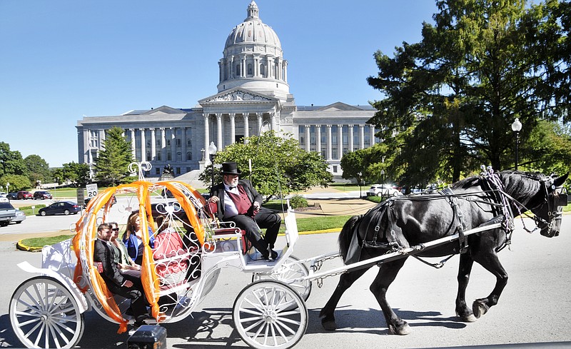 The St. Joseph Convention and Visitors Bureau hired carriage driver Wayne Duncan to bring a horse and carriage to help their CVB promote tourism in their area. He picked up the Division of Tourism Director, Katie Steele Danner and others for a brief ride downtown to the G2 Gallery for a luncheon to promote tourism in their northeast Missouri city. The carriage was pulled by Tower, an 8-year-old Bergeron draft horse. They definitely caught the attention of pedestrians and drivers downtown Tuesday. 