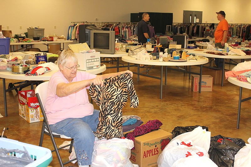 Event coordinator Anne Erbschloe sorts clothing for Callaway Christian Church's Fall Giveaway on Saturday. The church gathers clothing, baby items, household goods and small furniture throughout the year in preparation for the event.