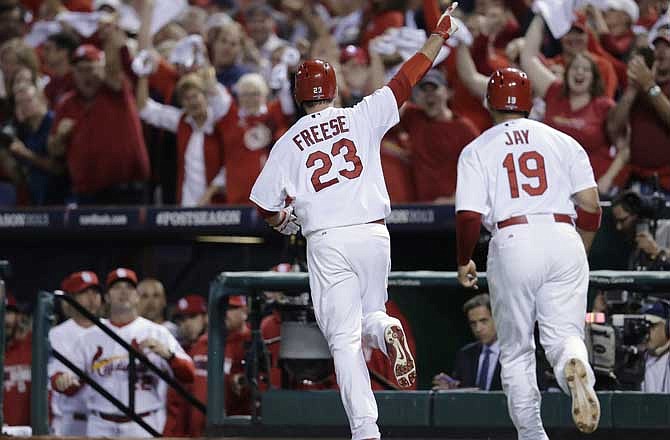 St. Louis Cardinals' David Freese (23) runs to the dugout with Jon Jay (19) after Freese drove in Jay with a two-run home run against the Pittsburgh Pirates in the second inning of Game 5 of a National League baseball division series, Wednesday, Oct. 9, 2013, in St. Louis.