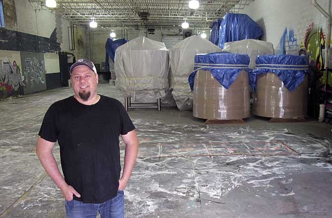 In this Oct. 3, 2013 photo, Mike Brenner, owner of Brenner Brewing in Milwaukee, stands in front of what he hopes to be his brewery. The federal government shutdown could leave America's craft brewers with a serious hangover. Stores will still offer plenty of suds. But the shutdown has closed an obscure agency that quietly approves new breweries, recipes and labels, which could create huge delays throughout the rapidly growing craft industry, whose customers expect a constant supply of inventive and seasonal beers.