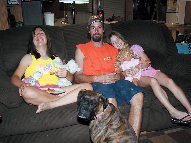 Alison Miller, 12, with her father Sean Miller and sister Desirae, 10. Seated in front is their pet boxer, Goon.