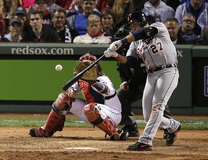 Detroit Tigers' Jhonny Peralta hits a double in front of Boston Red Sox catcher David Ross off Red Sox relief pitcher Craig Breslow in the eighth inning during Game 1 of the American League baseball championship series Saturday, Oct. 12, 2013, in Boston. 