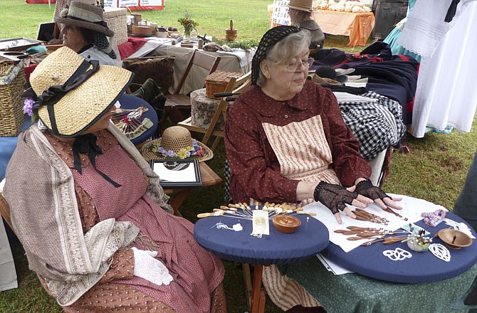 Nancy Sckunecht, St. Louis, and Lorry Fridinger, Lynchburg, Va., demonstrate how to make lace by attaching thread to bobbins. The lace is used as an accessory on clothing and other household textiles.