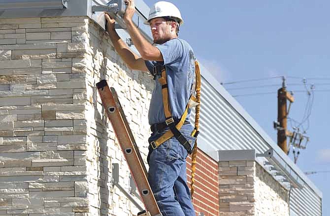 Electrician Brandon Bashore of Jeffries Electrical Service installs light bars over the area where signage will be installed on the new McDonald's at 3124 S. Ten Mile Dr. in Jefferson City. The new lights are LED, meaning they should be less expensive to operate and need little to no replacement. 