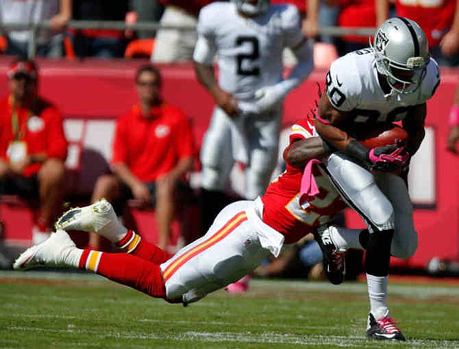 Oakland Raiders wide receiver Rod Streater (80) is tackled by Kansas City Chiefs free safety Kendrick Lewis (23) during the first half of an NFL football game at Arrowhead Stadium in Kansas City, Mo., Sunday, Oct. 13, 2013. 
