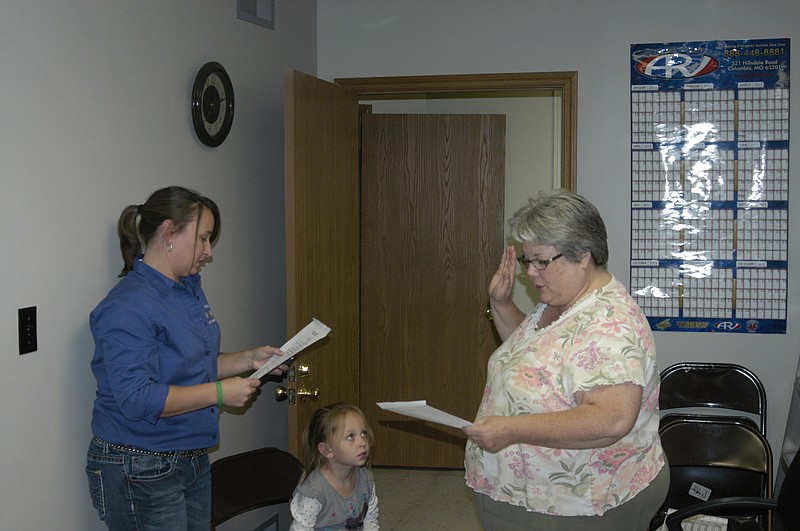 Democrat photo / David A. Wilson
Notary Tasha Knapheide, left, gives the oath of office to Becky Holloway Wednesday, Oct. 9, to become the newest board member of Mid-Mo Ambulance District. She will complete the term of Bob Sheridan who moved out of the district. Observing the ceremony is Tasha's daughter Kynna.