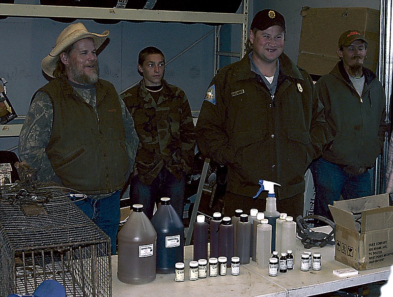 Democrat photo / David A. Wilson
Behind the display table, Trapper Dale Vert, far left, and Conservation Agent Nathan Hodges speak to those in attendance at the Trappers Clinic on Saturday, Oct. 5.