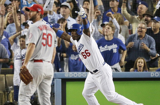 The Dodgers' Yasiel Puig celebrates in front of Cardinals starting pitcher Adam Wainwright after Puig hit a run-scoring triple during the fourth inning of Game 3 of the NL championship series Monday in Los Angeles.