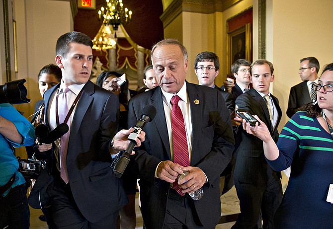 Rep. Steve King, R-Iowa, walks Tuesday from House Speaker John Boehner's office with reporters in pursuit at the Capitol. With time growing desperately short, House Republicans pushed for passage of legislation late Tuesday to prevent a threatened Treasury default, end a 15-day partial government shutdown and extricate divided government from its latest brush with a full political meltdown. 