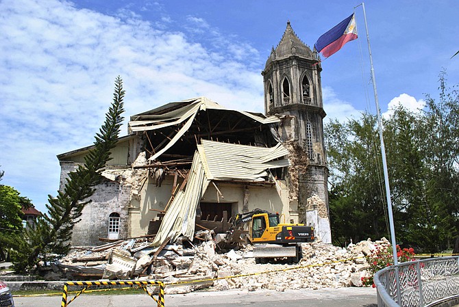 A crane shifts through the rubble of the damaged Our Lady of Assumption Parish church Tuesday following a 7.2-magnitude earthquake, at Dauis in Bohol, central Philippines. The tremor collapsed buildings, cracked roads and toppled the bell tower of the Philippines' oldest church Tuesday morning, causing multiple deaths across the central region and sending terrified residents into deadly stampedes.