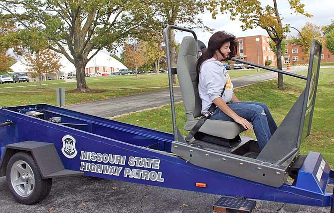 William Woods University sophomore Jenny Parr "crashes" to a stop on the Missouri Highway Patrol's Seat Belt Convincer, which emulates the force of a head-on collision at 5 mph.