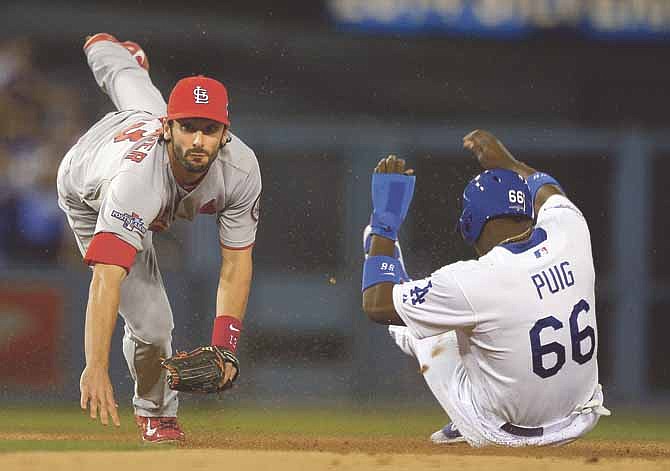 Los Angeles Dodgers' Yasiel Puig is out at second as St. Louis Cardinals' Matt Carpenter turns a double play on a ball hit by Juan Uribe during the sixth inning of Game 4 of the National League baseball championship series Tuesday, Oct. 15, 2013, in Los Angeles.