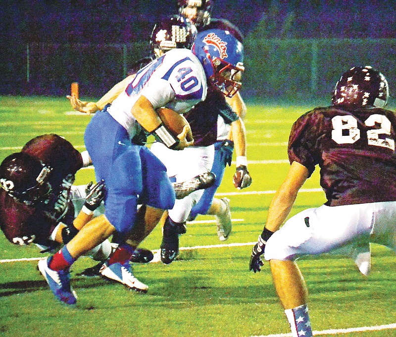 California's Jerry Lutz (40) charges through the Osage offensive line during Friday night's conference game at Osage.
