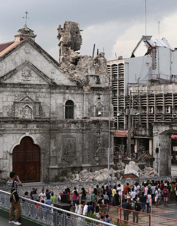 Residents look at the Basilica De Sto. Nino, or Basilica of the Holy Child, following a 7.2-magnitude earthquake that hit Cebu city in central Philippines. 