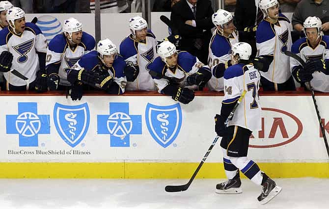 St. Louis Blues' T.J. Oshie (74) celebrates with teammates after scoring his goal against Chicago Blackhawks goalie Corey Crawford (50) during a shootout in an NHL hockey game in Chicago, Thursday, Oct. 17, 2013. The Blues won 3-2.