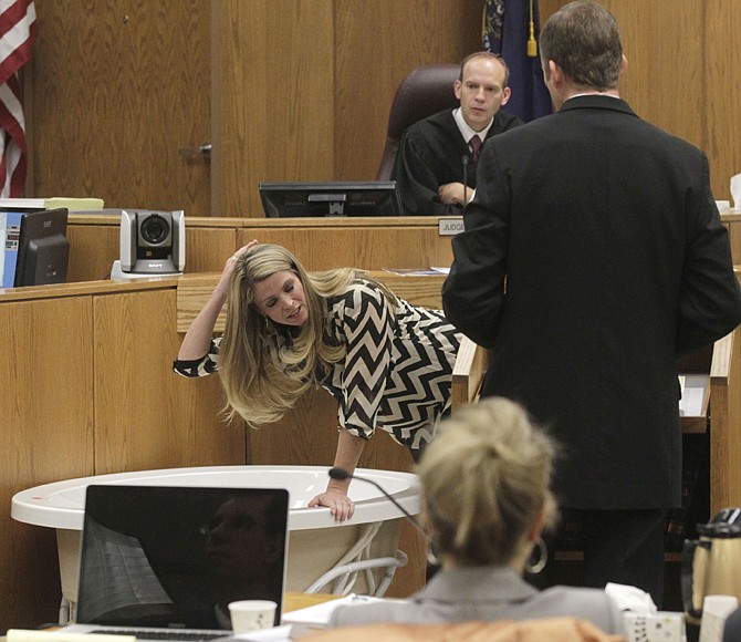 Kristi Daniels leans over a bathtub Friday to describe Michele MacNeill's body position when she was called to the home for help in 2007 during the trial of Martin MacNeill in Judge Derek Pullan's 4th District Court in Provo, Utah. MacNeill, a former Utah doctor, is accused of killing his wife, Michele, after convincing her to get a face-lift, giving her a lethal combination of prescription drugs for recovery and then helping her into the bathtub.