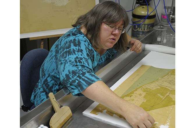 Conservator Sandy Hempe wash two of 58 maps brought to the Missouri State Archives for restoration by the Jefferson Barracks Heritage Foundation. 