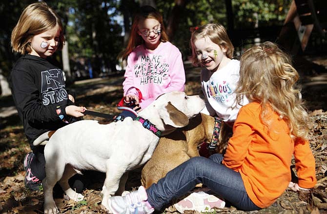 From left, Sienna Stafford, 7; Paige Bateman, 9; Arya Spencer, 3; and Sophia Carafeno, 3, play with two American bully and bassett hound mix puppies at the Rally to Rescue Adoptapalooza. The puppies, named Barret, left, and Gatlin, were rescued by People Helping Paws after their mother had been shot in the head while still pregnant.
