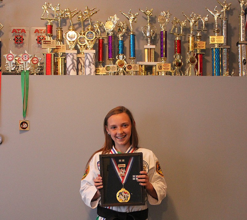 Adrea Shadbolt poses with her trophies and awards.