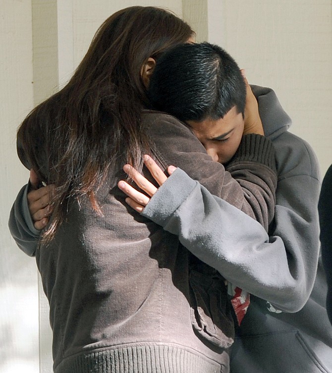 Jorge Martinez, 13, right, cries in his mother Norma's arms following the shooting that left two dead, including the shooter, at Sparks Middle School Monday. A student at the school opened fire on campus just before the starting bell Monday, wounding two boys and killing a teacher who was trying to protect other children, Sparks police and the victim's family members said.