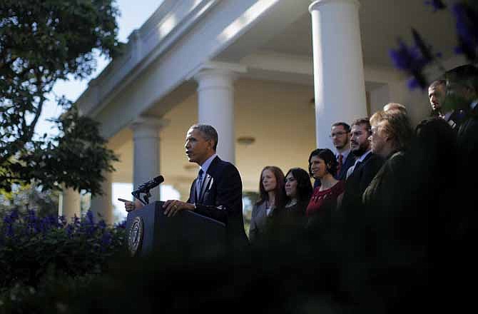 President Barack Obama, standing with supporters of his health care law, speaks in the Rose Garden of the White House in Washington, Monday, Oct. 21, 2013, on the initial rollout of the health care overhaul. Obama acknowledged that the widespread problems with his health care law's rollout are unacceptable, as the administration scrambles to fix the cascade of computer issues.