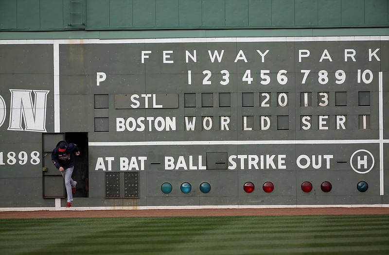 Cardinals pitcher Michael Wacha runs out of a scoreboard under the Green Monster before batting practice Tuesday at Fenway Park in Boston. The Cardinals and Red Sox are scheduled to meet in Game 1 of the World Series on Wednesday.