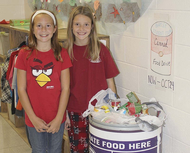 Bartley Student Council Vice President Grace Siegel, left, and President Zoe Schuster stand with the food already collected for the Food Bank for Central and Northeast Missouri. Today is the last day of the school's drive.