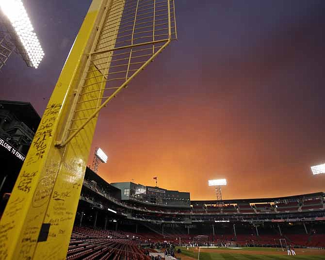 The right field foul pole, known as Pesky's Pole, is adorned with graffiti, as the sun sets over Fenway Park as the Boston Red Sox workout Tuesday, Oct. 22, 2013, in Boston. The pole was named after former Red Sox player and coach Johnny Pesky. The Red Sox are scheduled to host the St. Louis Cardinals in Game 1 of baseball's World Series on Wednesday.