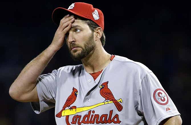 St. Louis Cardinals starting pitcher Adam Wainwright wipes his face as he pitches to Boston Red Sox's Mike Napoli during the second inning of Game 1 of baseball's World Series Wednesday, Oct. 23, 2013, in Boston.