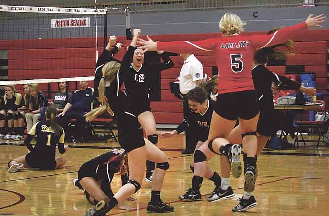 The Jefferson City Lady Jays celebrate after scoring the winning point to take the second game in Thursday night's match against Helias at Fleming Fieldhouse.