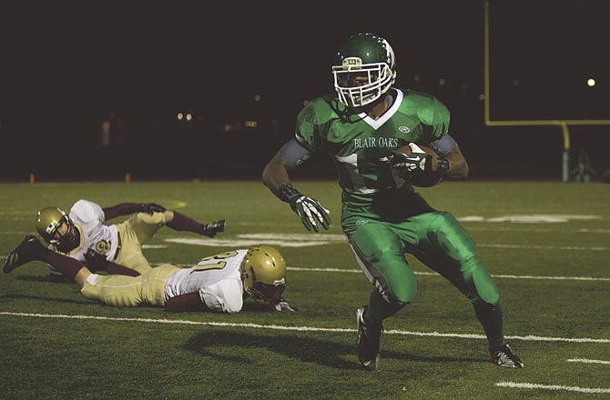 Blair Oaks running back Dominic Jamerson looks downfield after warding off two Eldon Mustang defenders during Friday night's game at Falcon Athletic Complex.