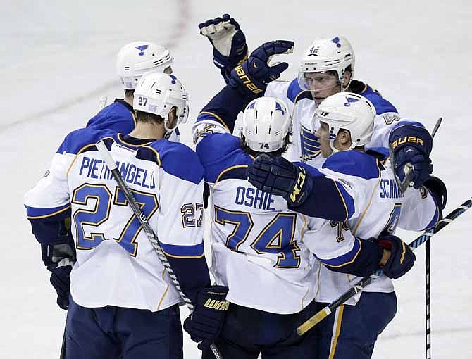 St. Louis Blues center T.J. Oshie (74) celebrates with Alex Pietrangelo (27), David Backes (42) and Jaden Schwartz (9) after scoring against the Nashville Predators in the second period of an NHL hockey game on Saturday, Oct. 26, 2013, in Nashville, Tenn.