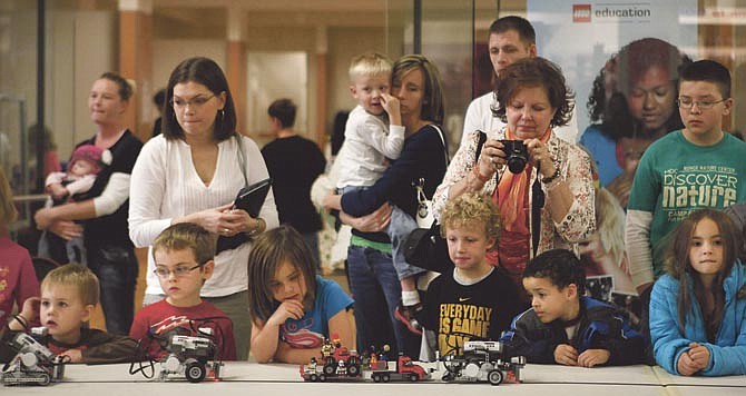 Kids and their families watch Saturday as the Jefferson City 4-H Robot Parade passes by inside Capital Mall in Jefferson City. The Robot Parade and Lego Block Party event was put on by the Cole County Robotics FIRST 4-H club.