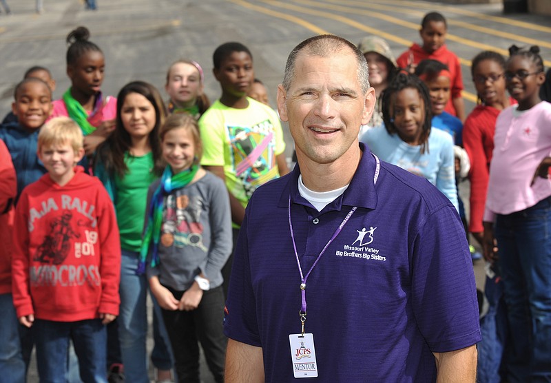 Scott Gehlert is seen on the playground at South Elementary School, surrounded by students happy to see him at school.