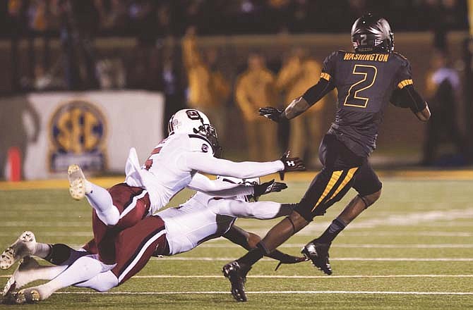 Missouri wide receiver L'Damian Washington runs past South Carolina's Jimmy Legree (left) and Brison Williams (bottom) as he scores on a 96-yard touchdown reception during the second quarter of Saturday night's game at Faurot Field.