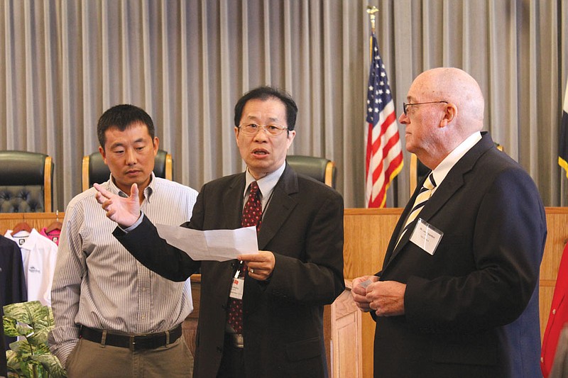 Flanked by Fulton businessman Richard Li, left, and Mayor LeRoy Benton, right, Peter Yu addresses a crowd of 15 other Chinese executives and local civic and business leaders during a business tour of Fulton Monday. The tour continues today, as the Fulton Area Development Corporation shows the foreign visitors several investment and business opportunities the area offers.