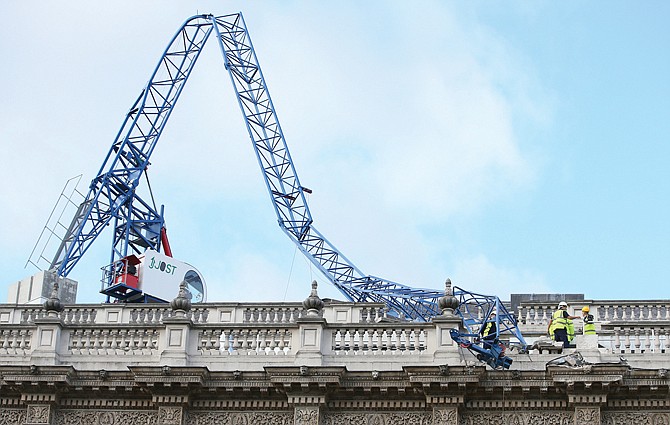 Engineers look at the damage Monday after a crane working on redevelopment at the Cabinet Office in Whitehall, in London, was brought down by high winds.