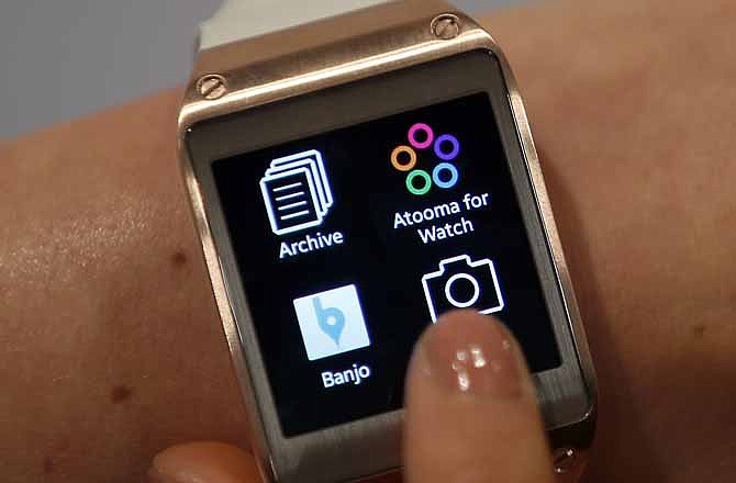 In this Wednesday, Sept. 4, 2013, file photo, a model touches the screen of a Samsung Galaxy Gear smartwatch in Berlin, Germany.