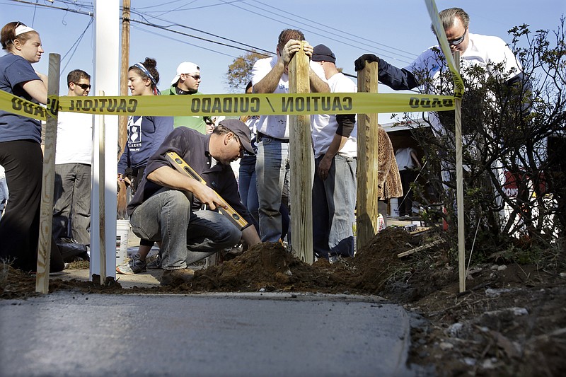 Volunteers work Tuesday on the outside of the Superstorm Sandy-damaged home of John and Angela Ciangiotto in Union Beach, N.J. Tuesday marks the one-year anniversary of Superstorm Sandy. A large Sandy-related fire on the boardwalk in September has slowed progress in the area.