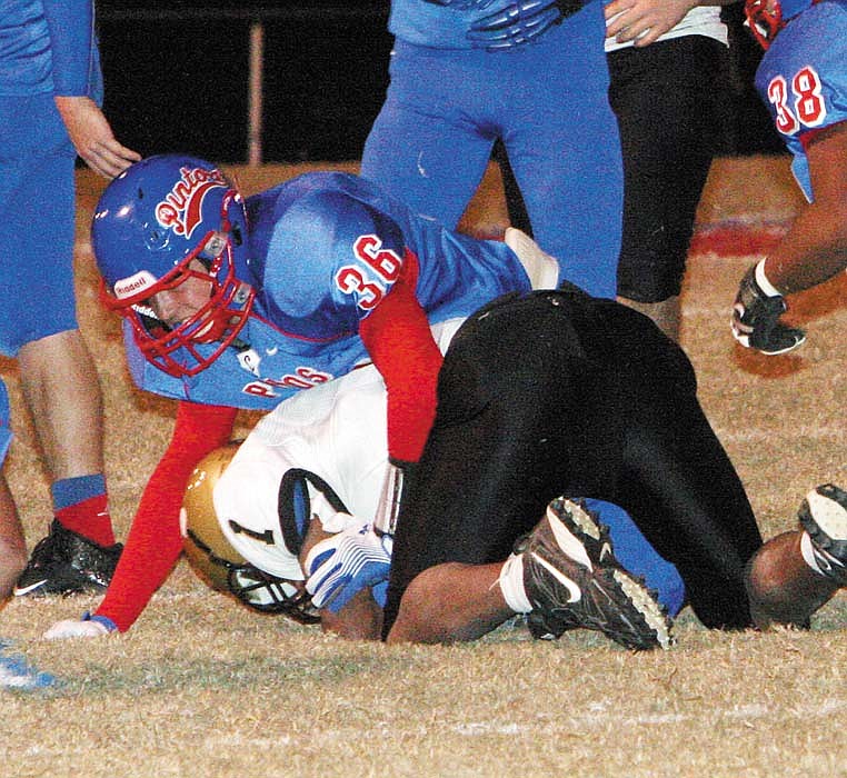 California's Brandan Gump (36) brings down Tiger Daryl Smith in the final seconds of the first half of Friday's conference game against Versailles. The Pintos won 63-12.
