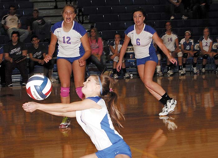 California's Libby Martin gets underneath a Russellville serve during the second set of the district match Monday at Fatima High School. Ready to assist, from left, are Cameron Meyer and Madilyn Safley.