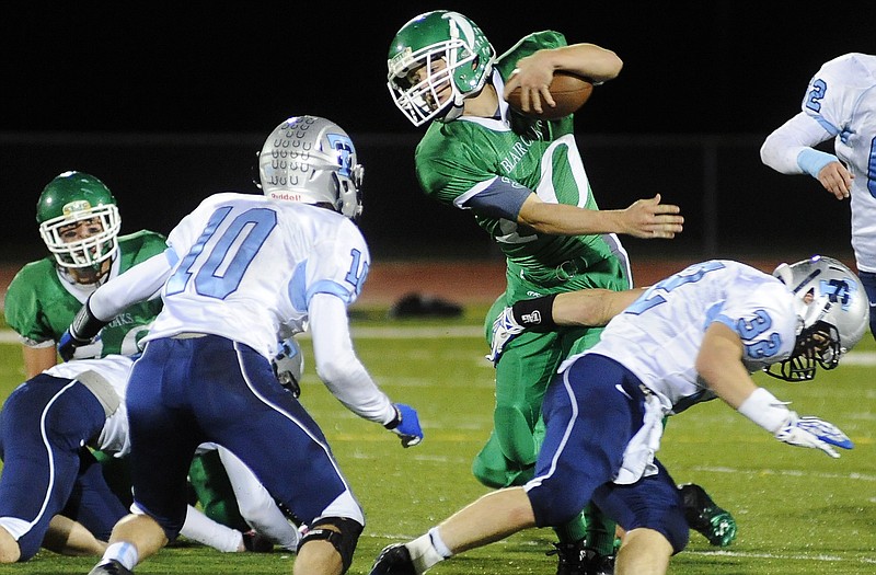 Blair Oaks quarterback Jordan Hair tosses aside Tolton Catholic linebacker Will Tindal after scrambling out of the pocket Thursday night in Wardsville.