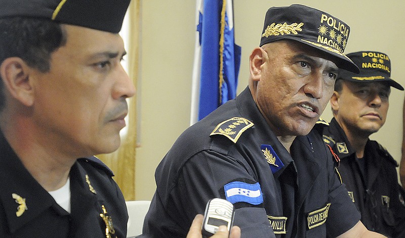 Honduras Police Chief Gen. Juan Carlos Bonilla, center, speaks in July 2012 to the press during a news conference in Tegucigalpa, Honduras. The five-star general was accused a decade ago of running deaths squads and today oversees a department suspected of beating, killing and "disappearing" its detainees.