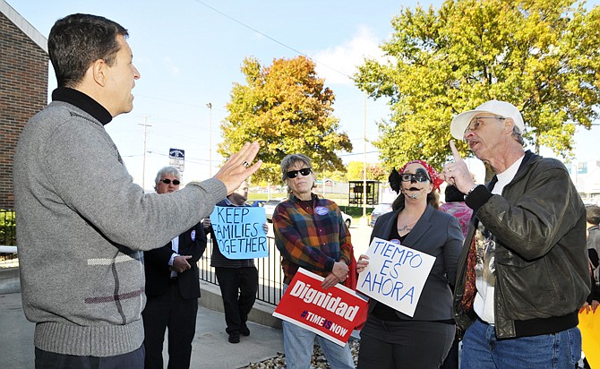 Robert Haslag, above at right, talks to Paul Sloca, left, after a group held a rally outside the 3rd District Congressman Blaine Luetkemeyer's Missouri Boulevard office. Rally participants were there to ask Luetkemeyer to support immigration reform. Haslag, of Centertown, addressed the crowd and later, Sloca, who is a spokesman for Luetkemeyer. Next to Haslag are activists Alison Dreith and Sue Gibson.
